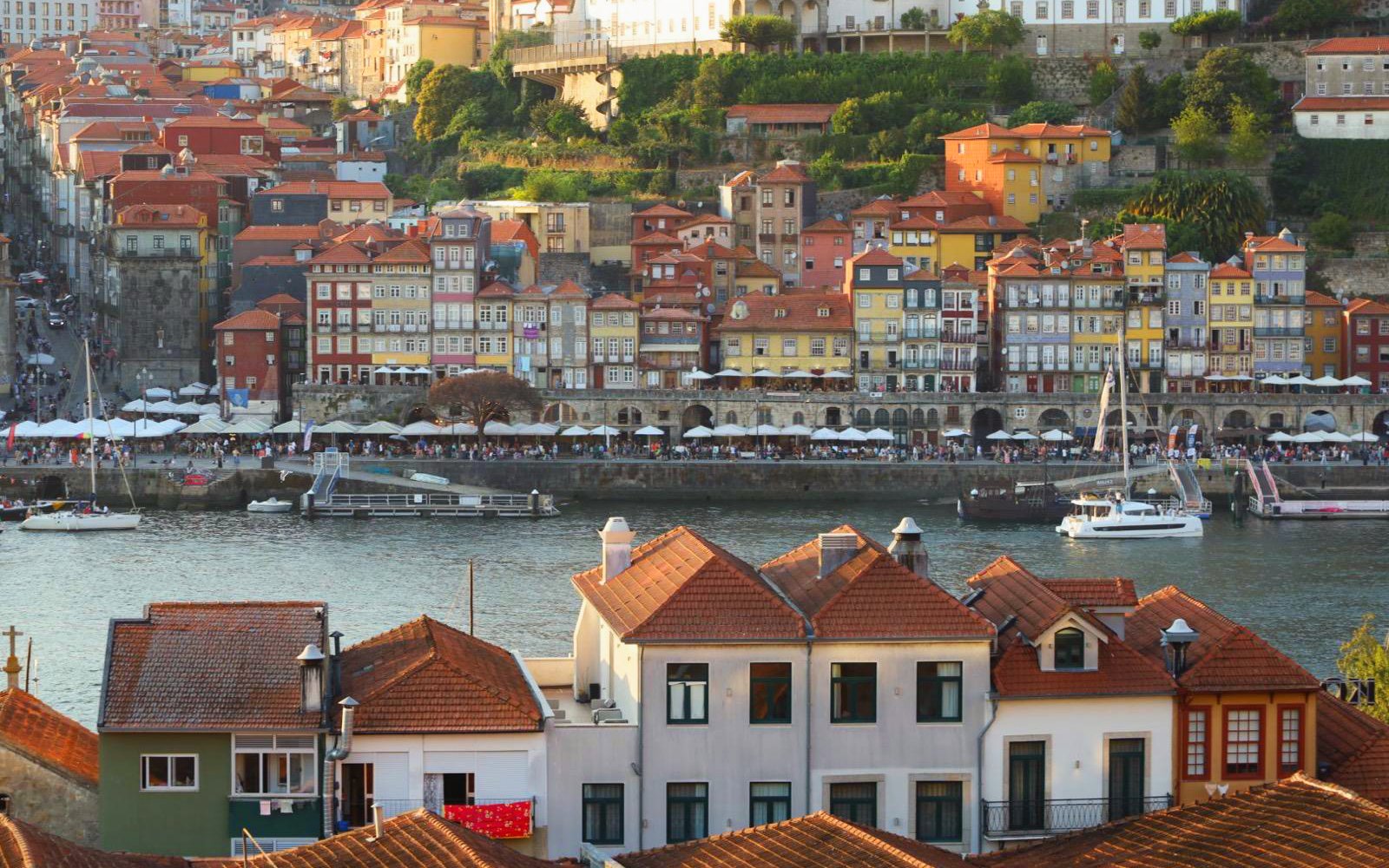 Colorful buildings along Porto river with boats near the boarding point.