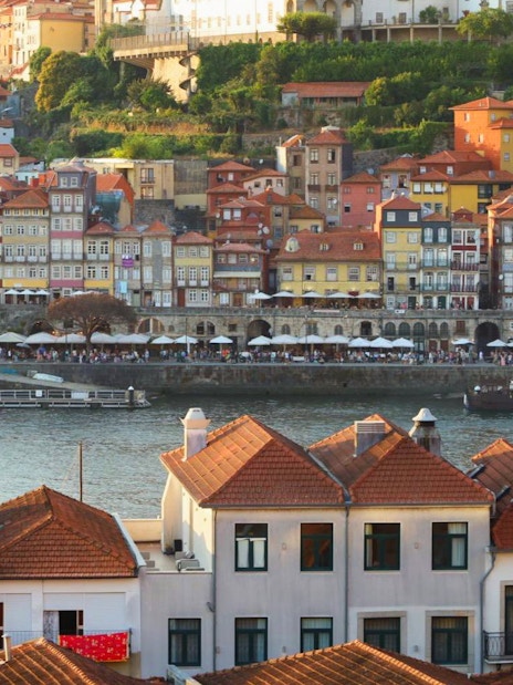 Colorful buildings along Porto river with boats near the boarding point.