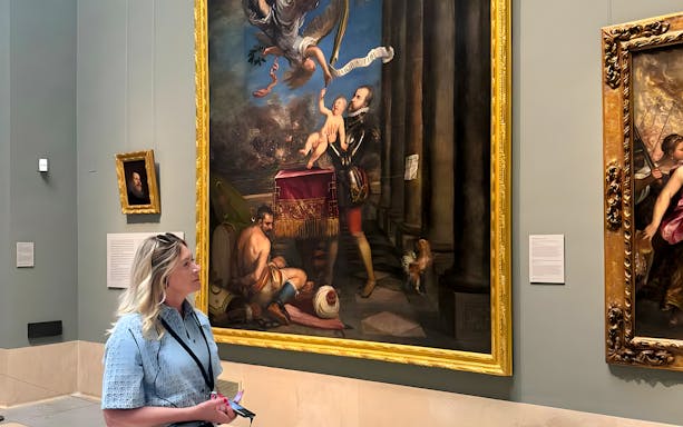 Woman observing a large painting in a museum gallery, Jhansi tour.