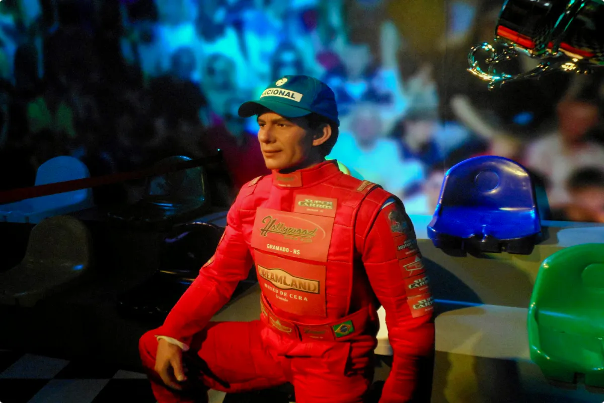 Wax figure of a race car driver in red suit at Foz do Iguaçu Wax Museum, Brazil.