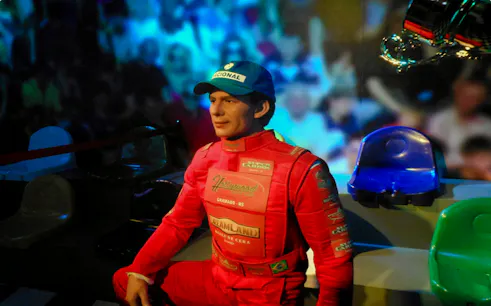 Wax figure of a race car driver in red suit at Foz do Iguaçu Wax Museum, Brazil.