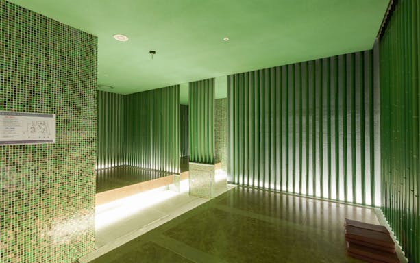 Spa Land Centum City Busan interior with green tiled walls and seating area.