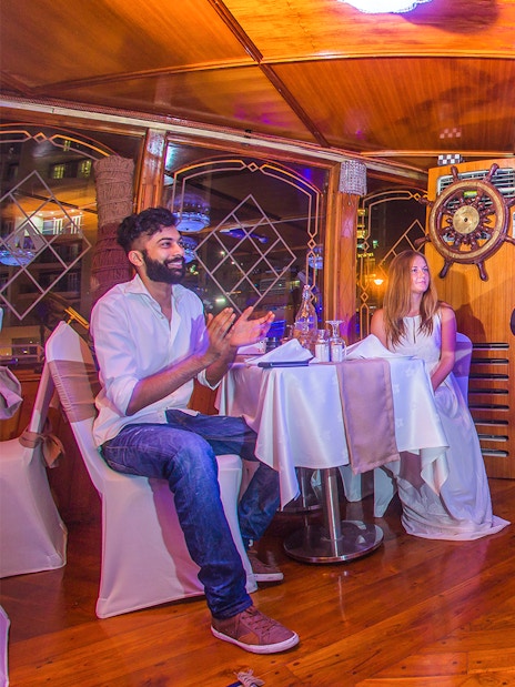 Dancers perform traditional Tanoura dance on Dubai Marina dhow cruise with guests dining.