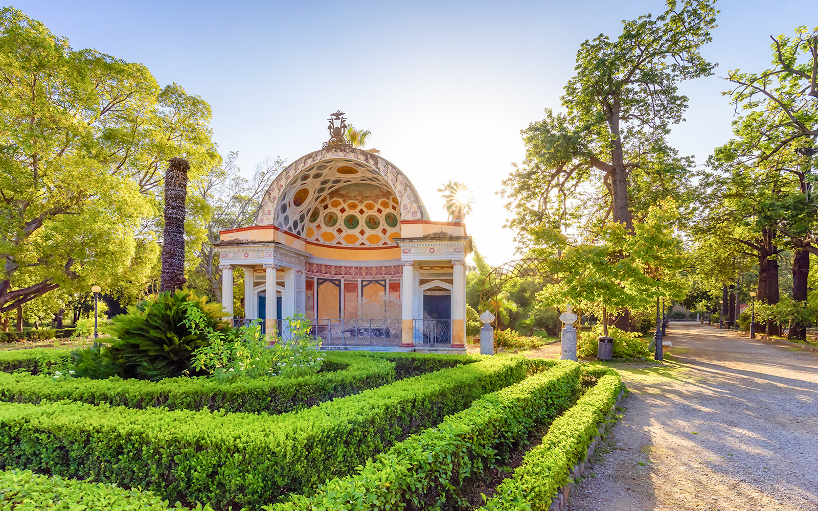Ornate pavilion surrounded by lush greenery at Palermo Botanical Garden.