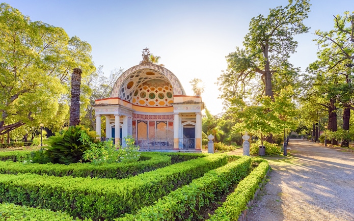 Ornate pavilion surrounded by lush greenery at Palermo Botanical Garden.