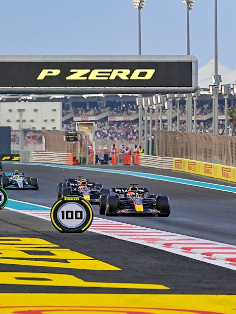 Formula 1 cars racing on Yas Marina Circuit during Abu Dhabi Grand Prix.