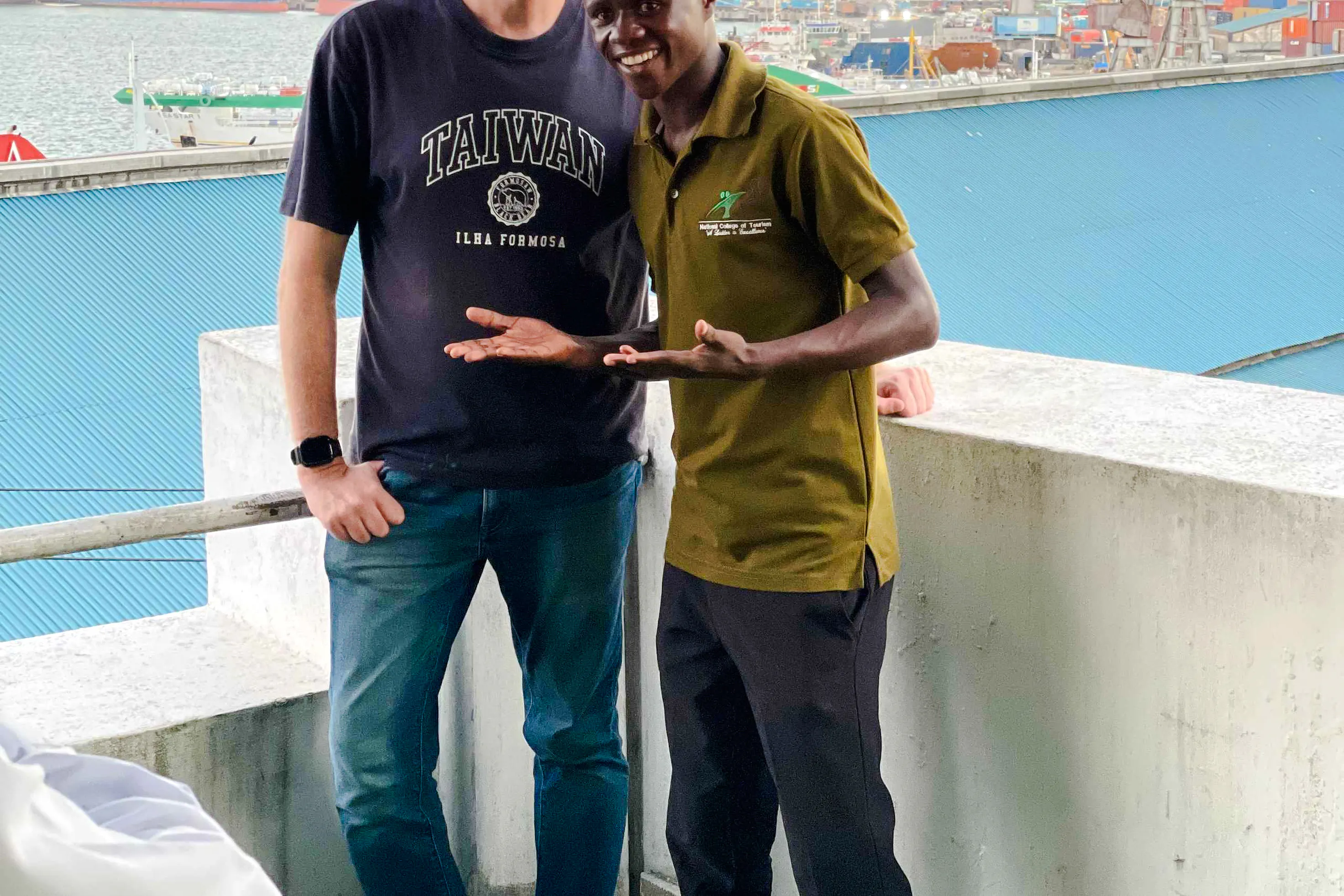 Tour guide and visitor at Dar es Salaam ferry terminal during Zanzibar day trip.