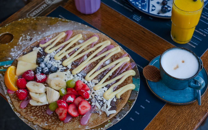 Dutch pancake with fruit and cream, served with coffee and juice, part of Rembrandt tour brunch in Amsterdam.