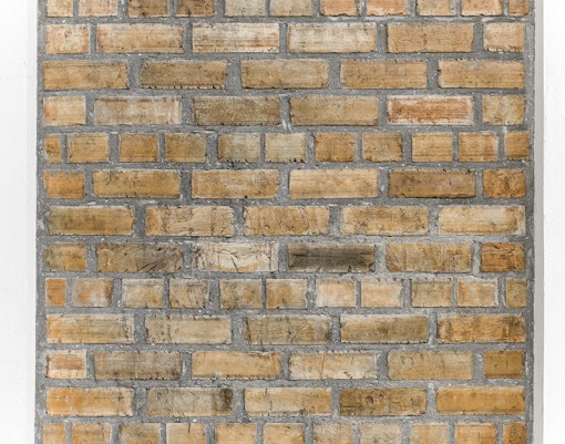 Ancient brick wall exhibit at a museum showcasing historical architecture.