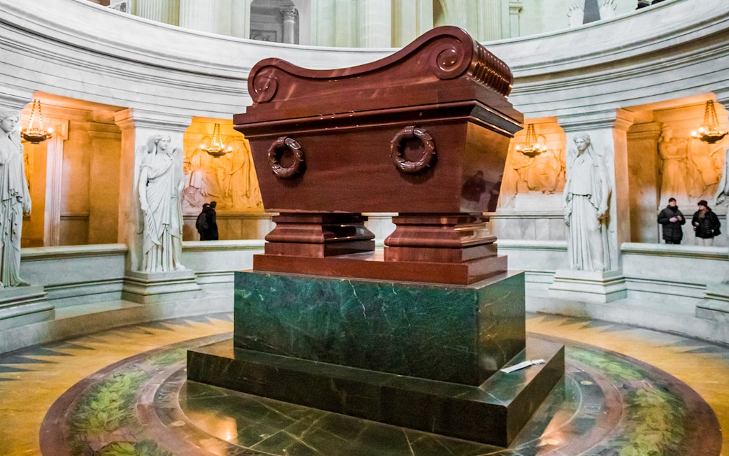 Tomb of Napoleon in Les Invalides, Paris, surrounded by statues and ornate architecture.