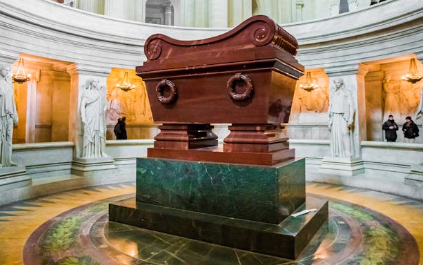 Tomb of Napoleon in Les Invalides, Paris, surrounded by statues and ornate architecture.