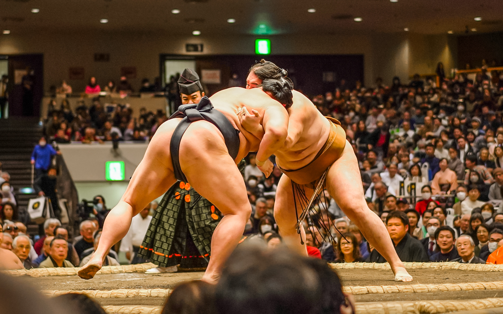 Sumo wrestlers competing in Tokyo's Ryogoku arena during a tournament.