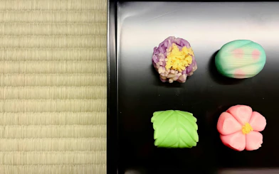 Traditional Japanese sweets on tatami mat at Kyoto tea ceremony.