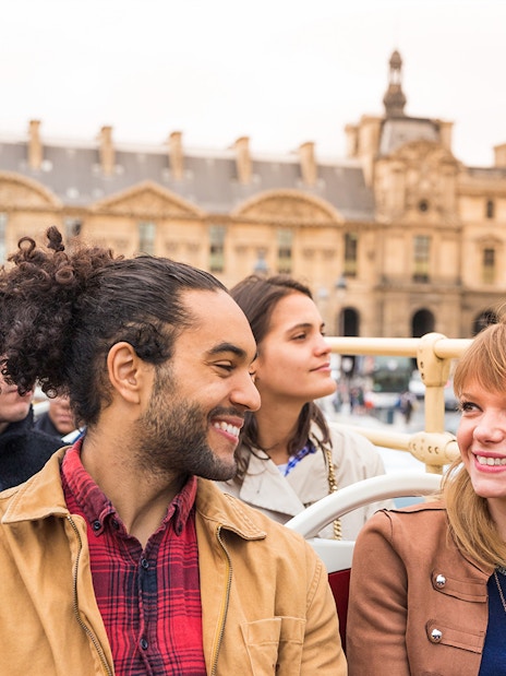 Tourists enjoying a Paris hop-on hop-off bus tour near Place VendĂŽme.