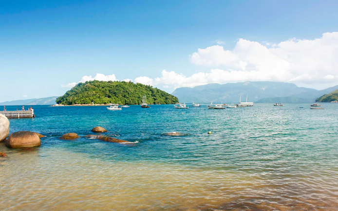 Boats anchored near lush island in Angra Do Reis, viewed from Conceição de Jacareí.