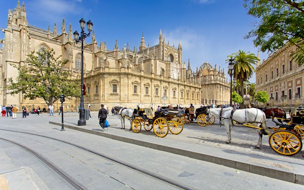 Seville Cathedral with horse-drawn carriages in front, part of Segway tour.