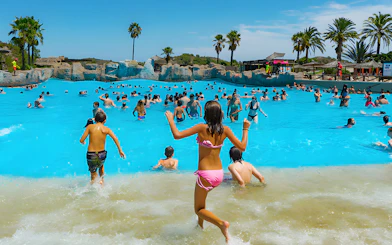 Visitors enjoying the wave pool at Aquopolis Cullera beach.