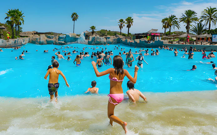 Visitors enjoying the wave pool at Aquopolis Cullera beach.