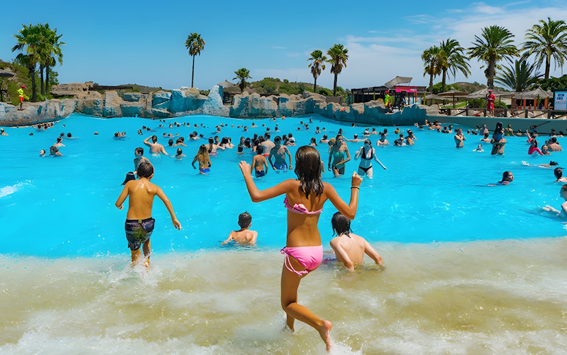 Visitors enjoying the wave pool at Aquopolis Cullera beach.