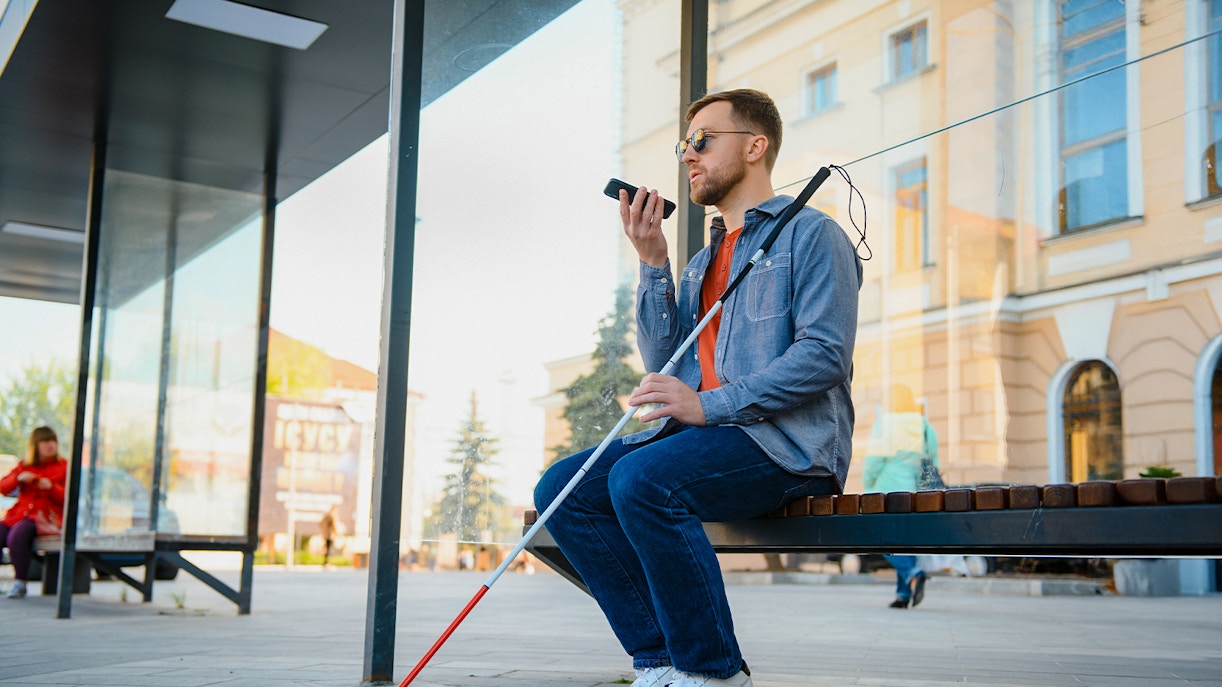 Visually impaired man with walking stick and glasses