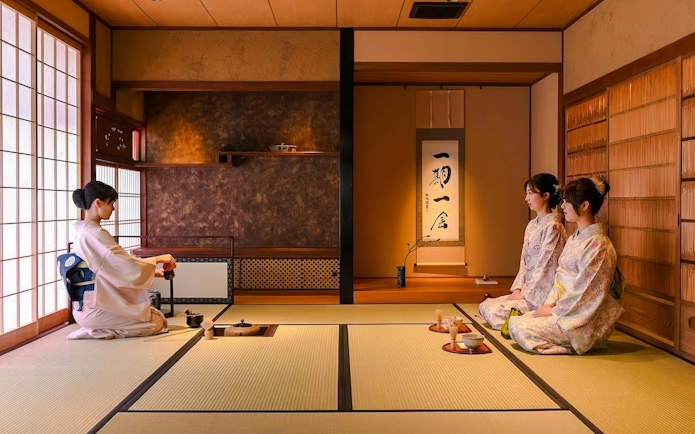 Kimono-clad women participating in a tea ceremony at a traditional Japanese house.