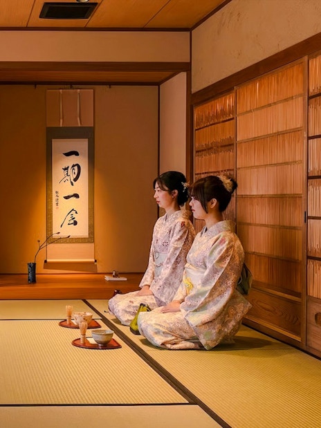 Kimono-clad women participating in a tea ceremony at a traditional Japanese house.