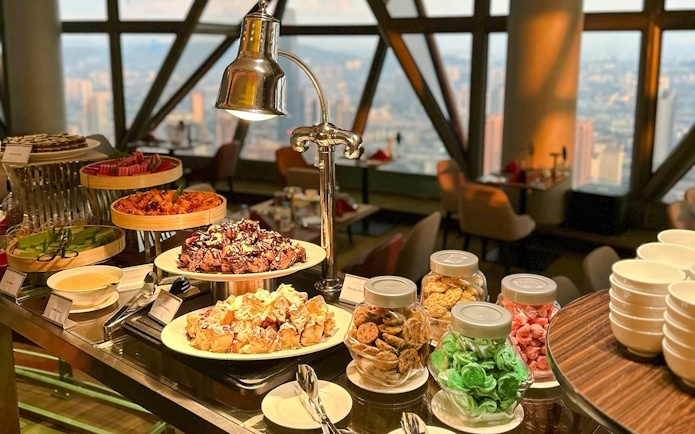 Lunch buffet spread at ORBIT Revolving Dining, KL Tower, featuring desserts and snacks.