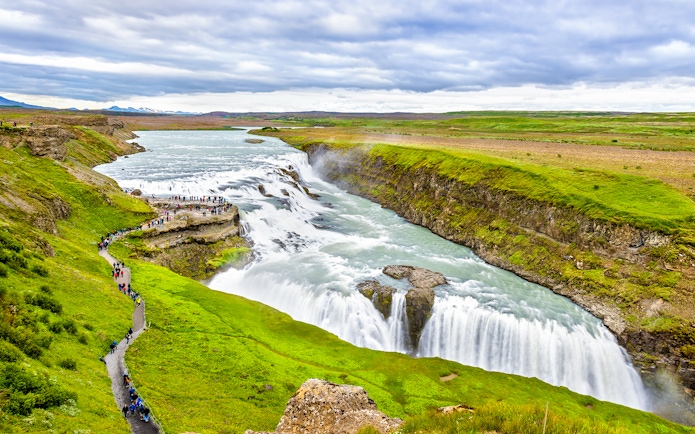 Tourists walking along a path near Gullfoss waterfall, part of Reykjavik Golden Circle Day Tour.