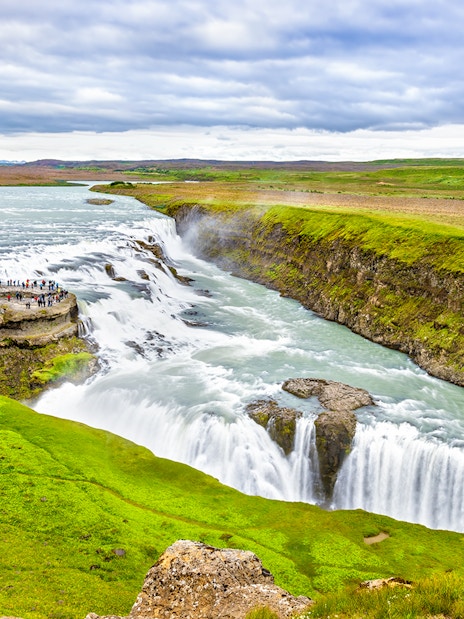 Tourists walking along a path near Gullfoss waterfall, part of Reykjavik Golden Circle Day Tour.
