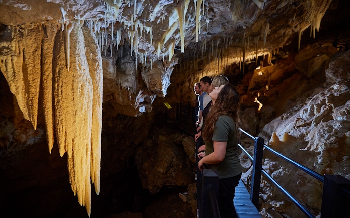 Visitors exploring stalactites in Ngilgi Cave during a semi-guided tour.