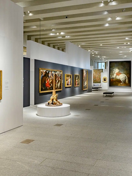 Royal Collections Gallery interior with paintings and sculptures, Madrid.