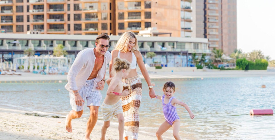 Family playing on the beach at Riva Beach Club, Dubai.
