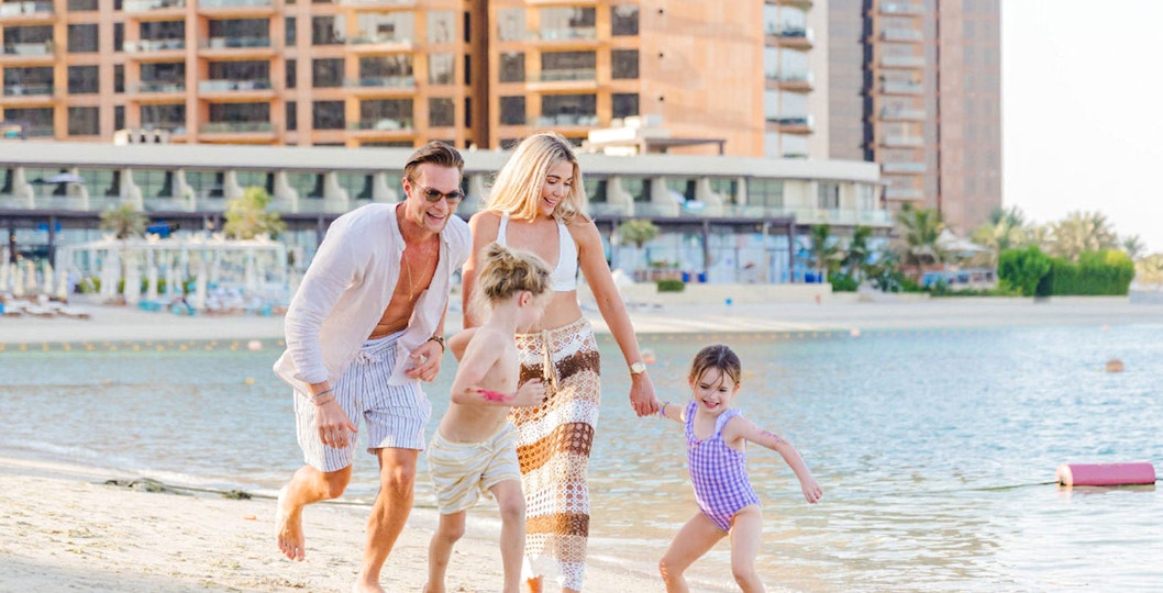 Family playing on the beach at Riva Beach Club, Dubai.