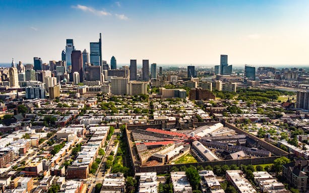 Aerial view of Philadelphia skyline with Eastern State Penitentiary in foreground.