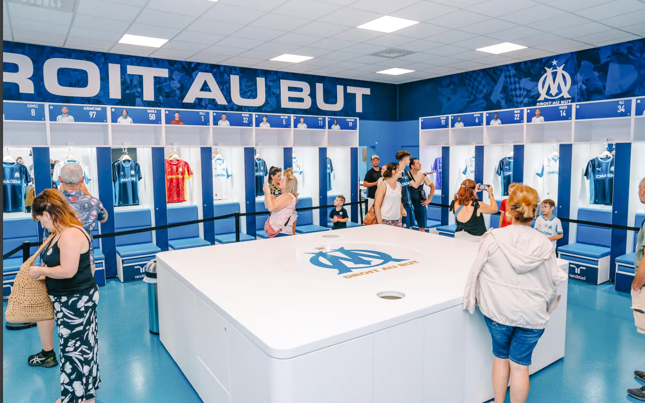 Visitors exploring the locker room during a Velodrome stadium tour in Marseille.