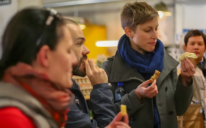People tasting local food during Rotterdam boat sightseeing tour.