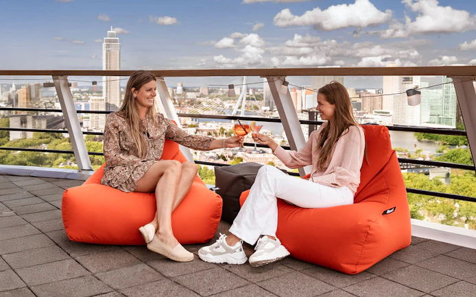 Guests enjoying drinks on the Euromast rooftop with Rotterdam skyline.