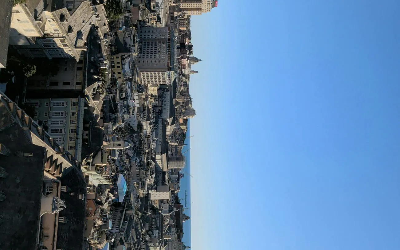 Aerial view of Genoa cityscape with historic buildings and distant sea, part of the self-guided exploration game.