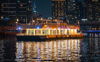 Alexandra Sea Lounge Dhow Cruise illuminated at night on Dubai Marina.