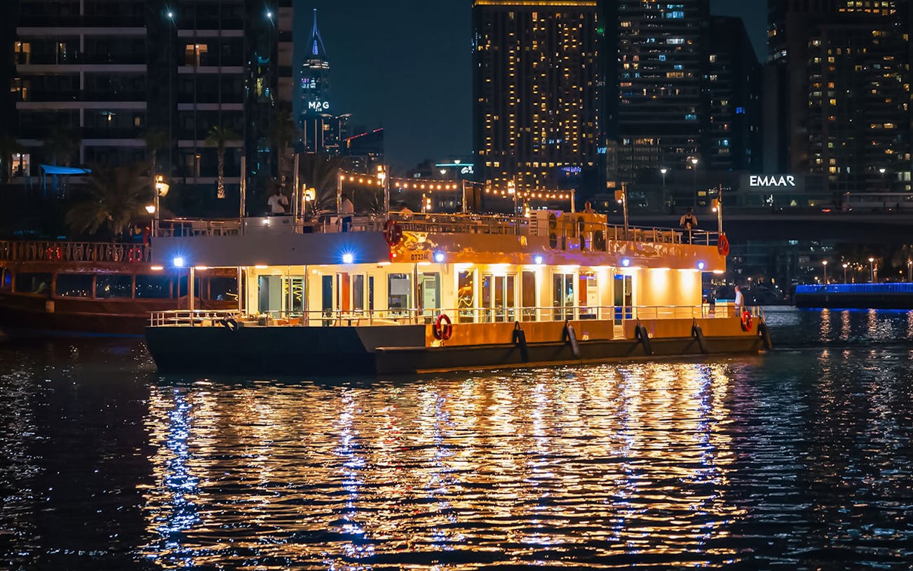 Alexandra Sea Lounge Dhow Cruise illuminated at night on Dubai Marina.