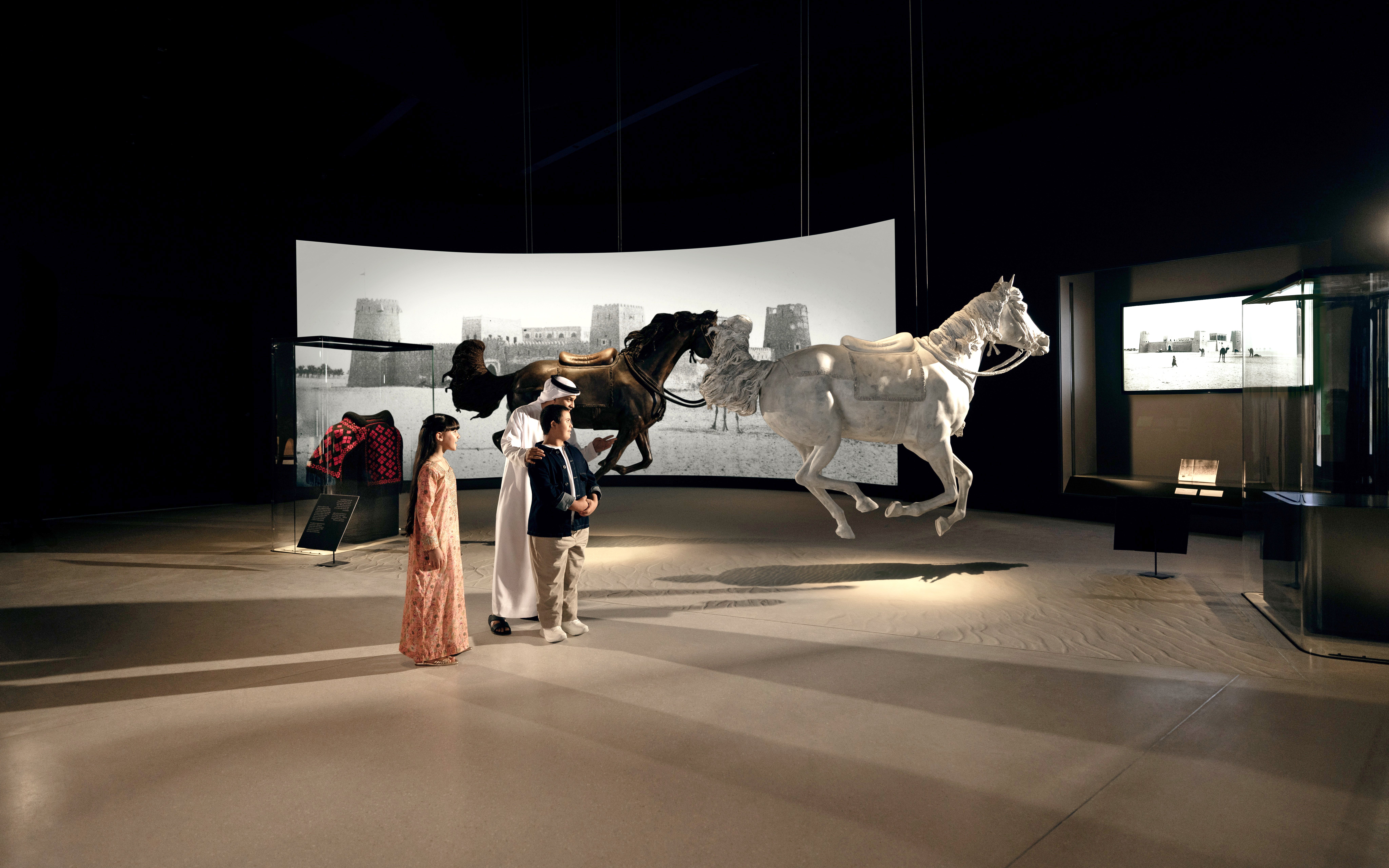 Visitors observing horse sculptures at Zayed National Museum, Abu Dhabi exhibit.