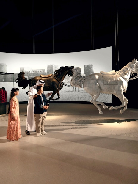Visitors observing horse sculptures at Zayed National Museum, Abu Dhabi exhibit.