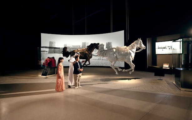 Visitors observing horse sculptures at Zayed National Museum, Abu Dhabi exhibit.
