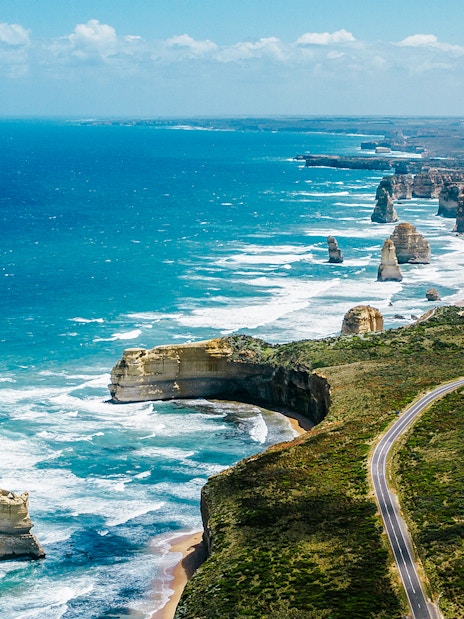 Aerial view of the Great Ocean Road with coastal cliffs and rock formations in Australia.