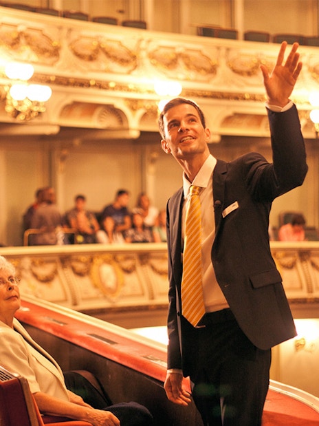 Tour guide leading a group through the ornate interior of the Semperoper in Dresden.