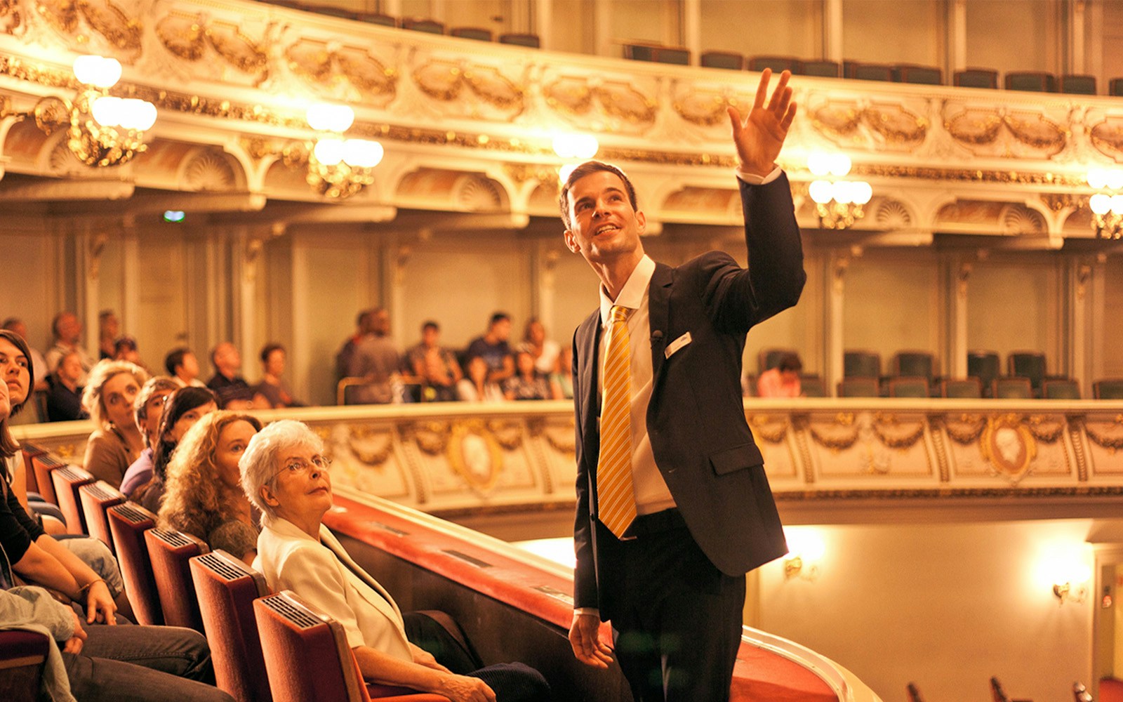 Tour guide leading a group through the ornate interior of the Semperoper in Dresden.