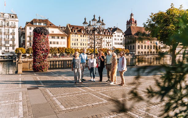 Group of people walking around Lucerne city hall bridge with guide, Lucerne
