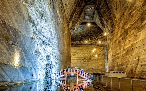 Slanic Salt Mine interior with illuminated walls and a wooden bridge, Bucharest day trip.