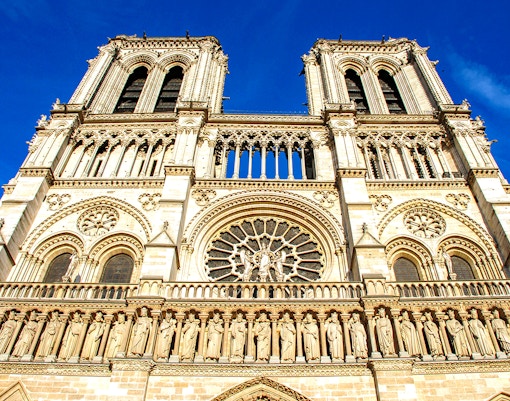 Notre-Dame Cathedral facade with tourists using audio guides in Paris.