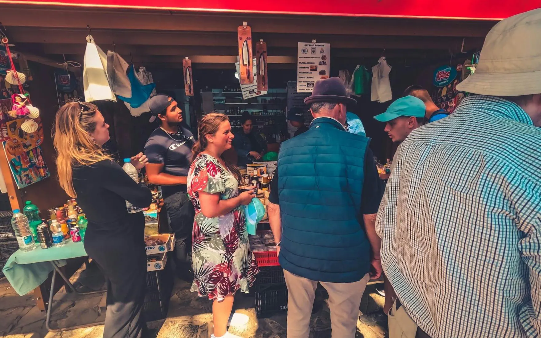 Tourists exploring a local market stall in Gran Canaria during a volcano sunset tour.